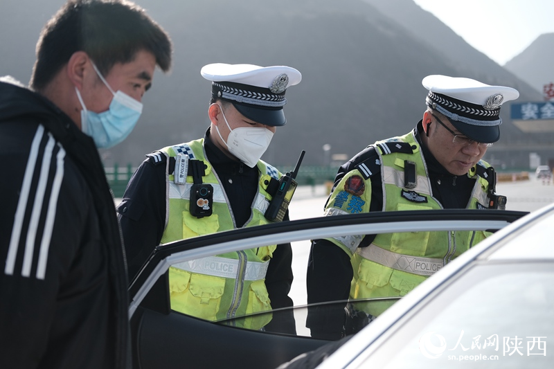 賀超和同事在西漢高速澇峪口收費站前檢查返鄉(xiāng)車輛出行安全情況。人民網(wǎng)記者吳超攝