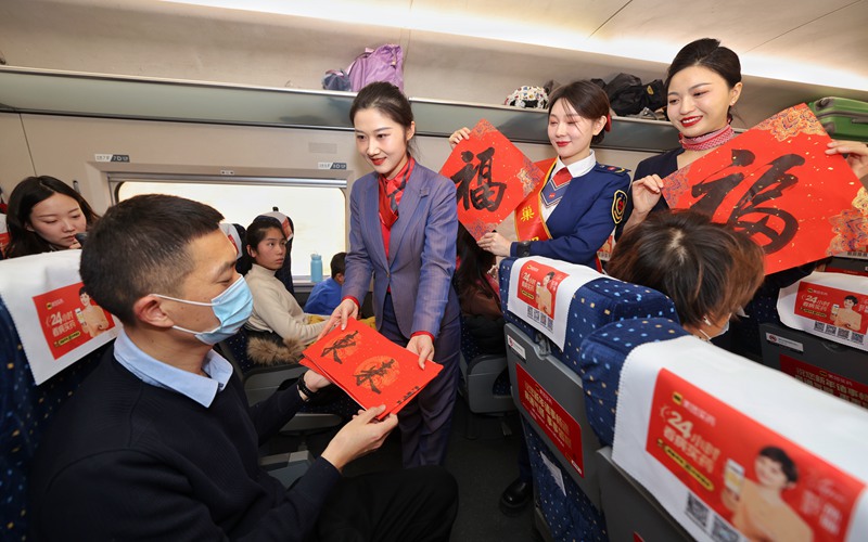 列車工作人員為旅客送上新春對聯(lián)。劉松霖 攝