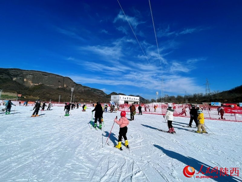 雪友們?cè)诨﹫?chǎng)滑雪，盡情體驗(yàn)滑雪運(yùn)動(dòng)帶來的快樂。人民網(wǎng)記者 魏鑫攝