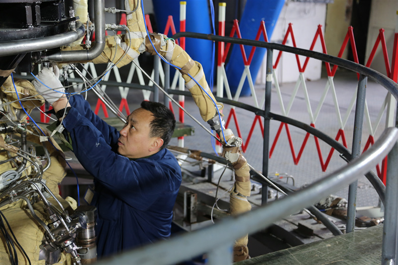 工作人員正在對(duì)試車臺(tái)上的火箭發(fā)動(dòng)機(jī)進(jìn)行調(diào)試。航天科技集團(tuán)六院供圖
