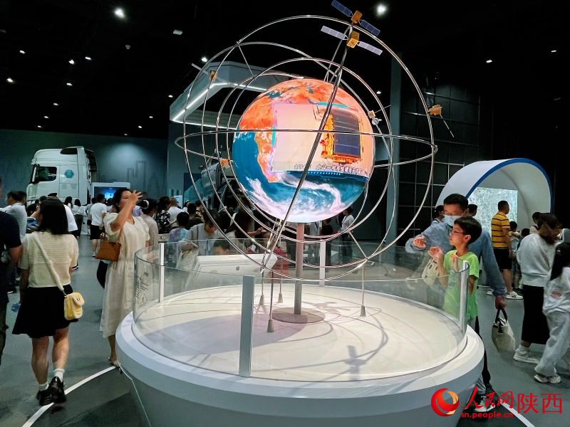  “逐夢空天”展區(qū)，市民游客在展品前駐足，探索科學的奧秘。人民網(wǎng)記者 魏鑫攝