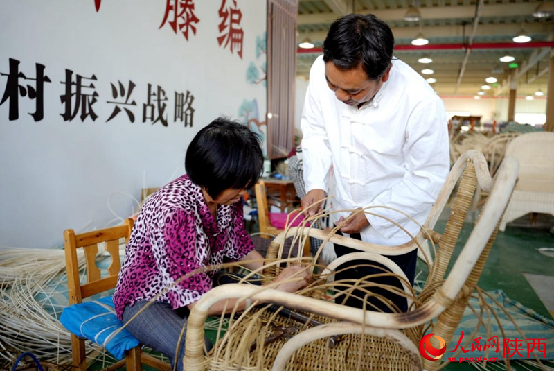陳良順（右）正在教授工人藤編技藝。人民網(wǎng)記者 鄒星攝