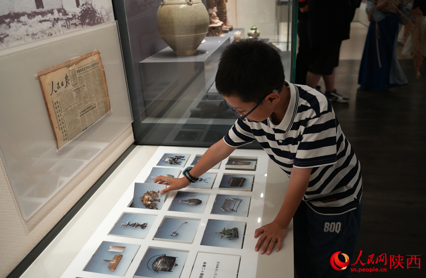 一名小學(xué)生在陜西考古博物館體驗(yàn)互動(dòng)裝置。人民網(wǎng)記者 李志強(qiáng)攝