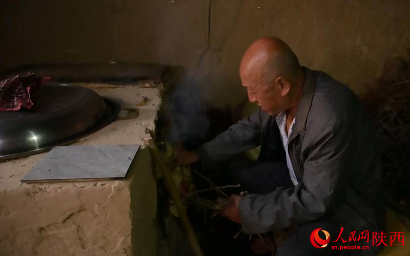 左大爺在窯洞里點(diǎn)火燒水。人民網(wǎng)記者 白鴿攝