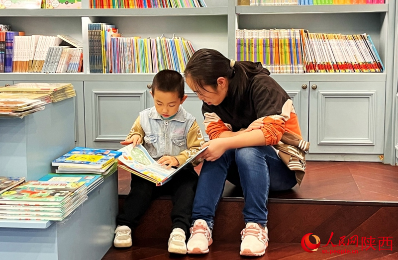 小朋友在家人的陪伴下閱讀。人民網(wǎng)記者 魏鑫攝