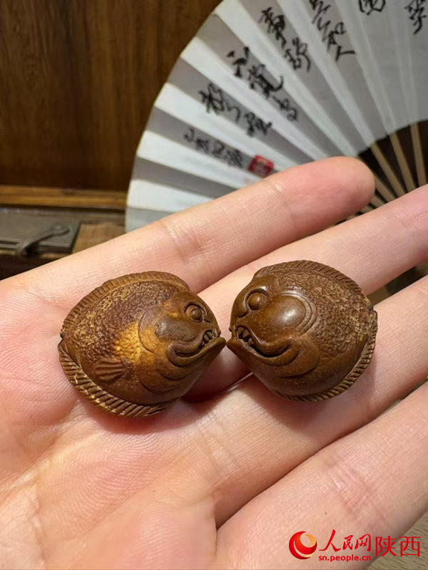 用果核雕刻的“小魚”。人民網(wǎng) 王麗攝