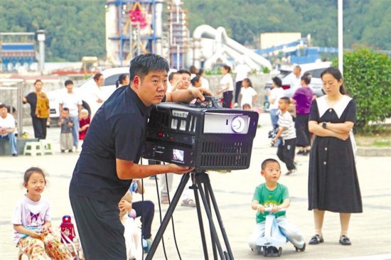6月5日，在旬陽市白柳鎮(zhèn)白柳社區(qū)，來榮安在調(diào)試電影放映設(shè)備。記者 董劍南攝